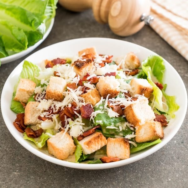 Tony's Pizza Caesar salad with crisp romaine, croutons, bacon bits, and shredded Parmesan cheese.