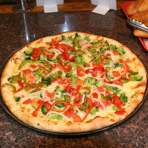 Tony's Pizza's vegetable pizza, topped with broccoli, tomatoes, onions, and bell peppers.